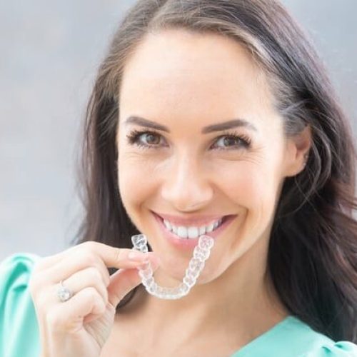 Invisalign,Orthodontics,Concept,-,Young,Attractive,Woman,Holding,-,Using Invisalign,Orthodontics,Concept,-,Young,Attractive,Woman,Holding,-,Using